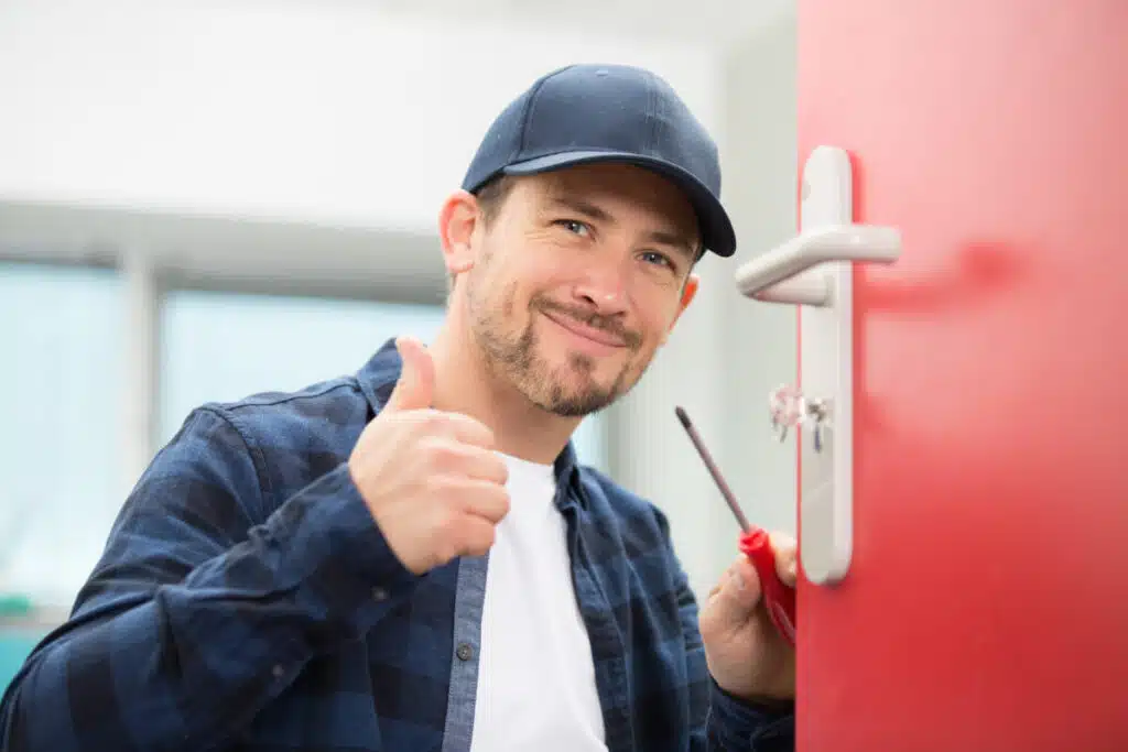 a man holding a screwdriver and smiling at the camera